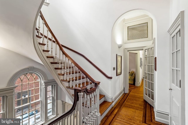 foyer entrance featuring dark wood-type flooring and a towering ceiling