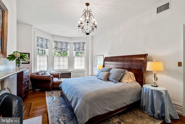 bedroom featuring ornamental molding, a notable chandelier, and dark parquet flooring