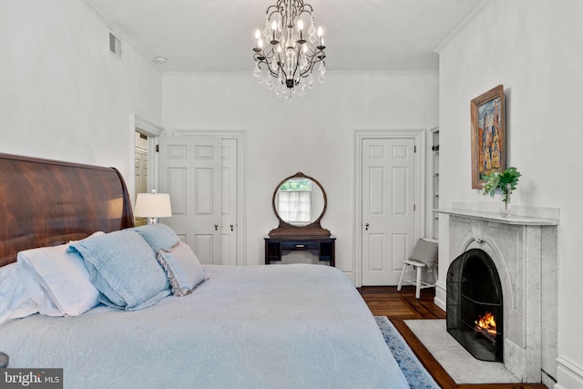 bedroom featuring crown molding, an inviting chandelier, and hardwood / wood-style floors