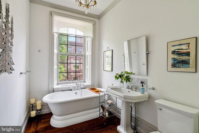 bathroom featuring a wealth of natural light, hardwood / wood-style floors, a bathtub, and toilet