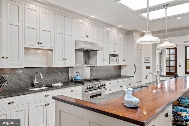 kitchen featuring a kitchen island, exhaust hood, high end stainless steel range, decorative light fixtures, and white cabinetry