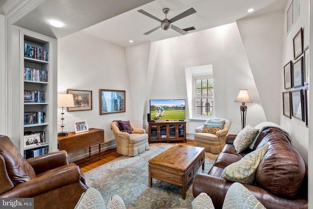 living room with hardwood / wood-style floors, built in features, and ceiling fan