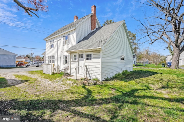 back of property featuring a lawn