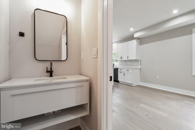 kitchen featuring white cabinetry, decorative light fixtures, a kitchen island, black appliances, and light wood-type flooring