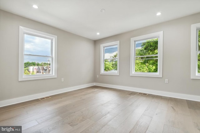 unfurnished bedroom featuring a closet, light hardwood / wood-style flooring, and ensuite bath