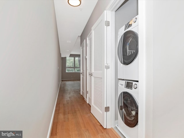 washroom with light wood-type flooring and stacked washer / drying machine