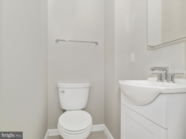 bathroom with tile patterned flooring, vanity, and toilet