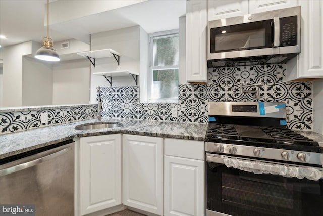 kitchen with tasteful backsplash, white cabinetry, stainless steel appliances, and light stone counters