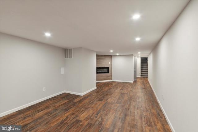 interior space with a large fireplace and dark hardwood / wood-style floors