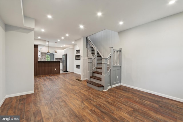 unfurnished living room with dark wood-type flooring