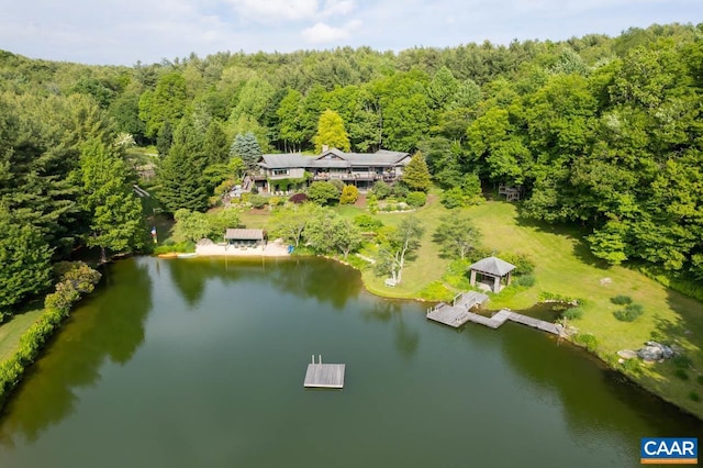 drone / aerial view featuring a forest view and a water view