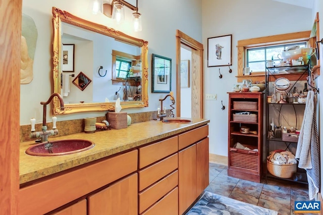 bathroom featuring a healthy amount of sunlight, double vanity, and a sink