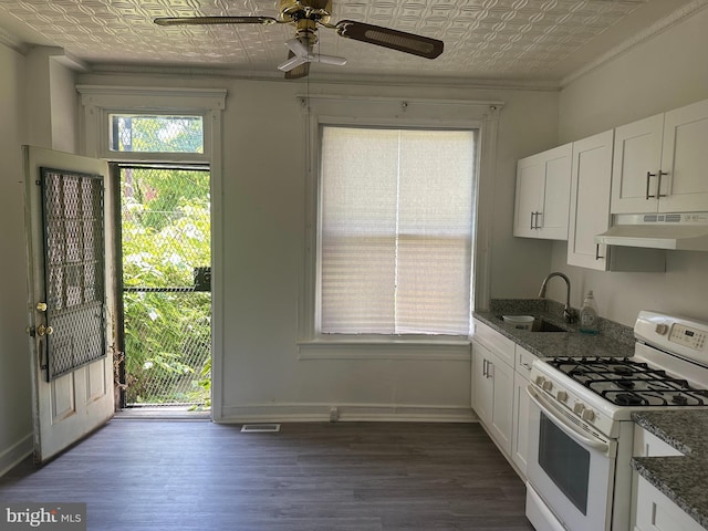 kitchen featuring white cabinets, white gas range, sink, and dark stone countertops