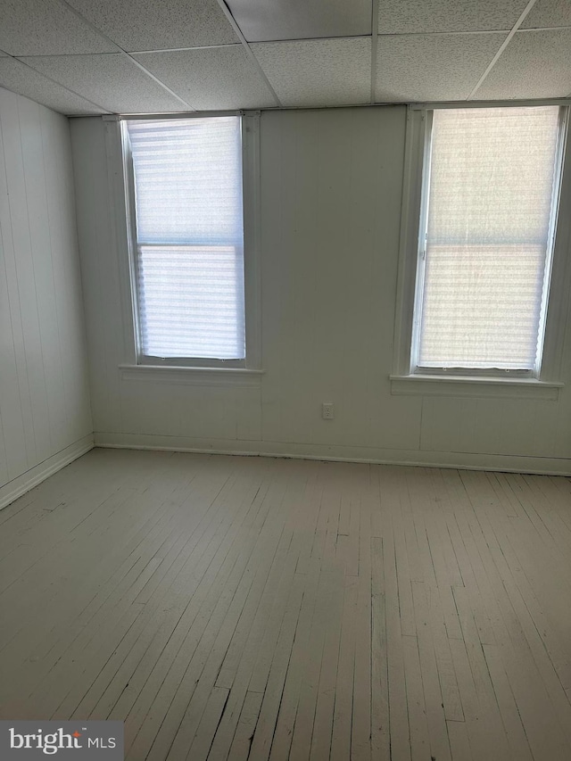 unfurnished room featuring light wood-type flooring and a drop ceiling