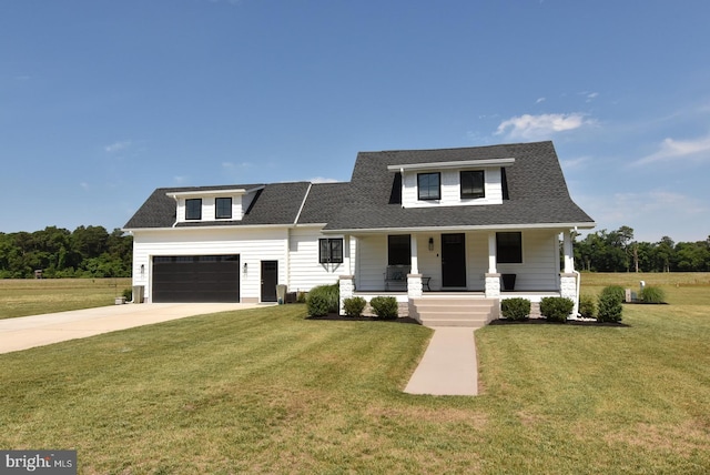 view of front of home featuring covered porch, a garage, and a front lawn