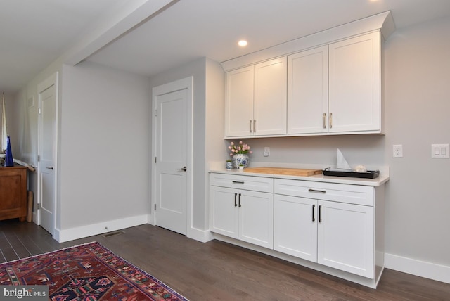 bar featuring dark hardwood / wood-style floors and white cabinetry