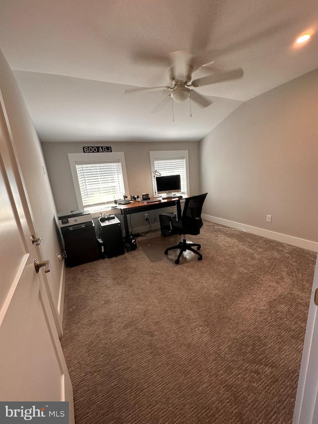 carpeted office space with a textured ceiling, ceiling fan, and vaulted ceiling