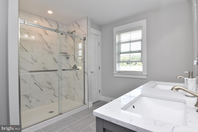 bathroom with a shower with door and vanity