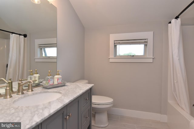 full bathroom featuring vanity, a healthy amount of sunlight, shower / bath combo, and toilet