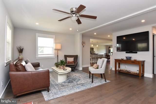 living room featuring ceiling fan and dark wood-type flooring