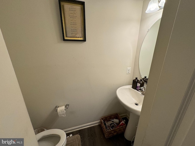 bathroom with toilet, wood-type flooring, and sink