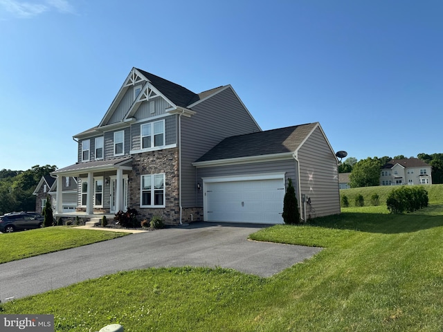 view of front of property featuring a front yard, a porch, and a garage