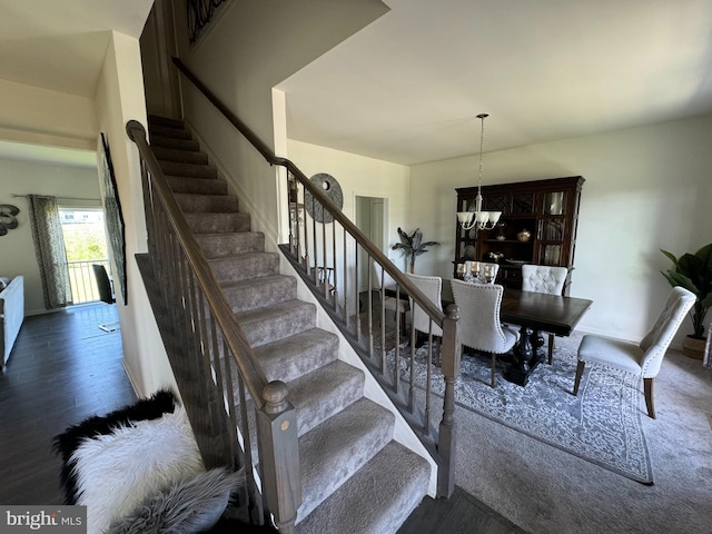 stairway featuring hardwood / wood-style floors and a notable chandelier