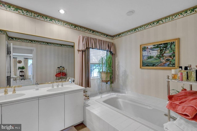 bathroom featuring vanity and tiled tub