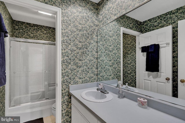 full bathroom with tile patterned flooring, vanity, enclosed tub / shower combo, and toilet