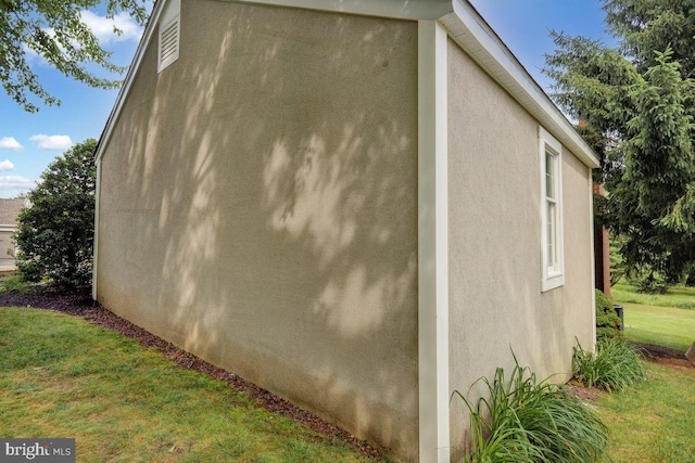 view of side of home with a yard