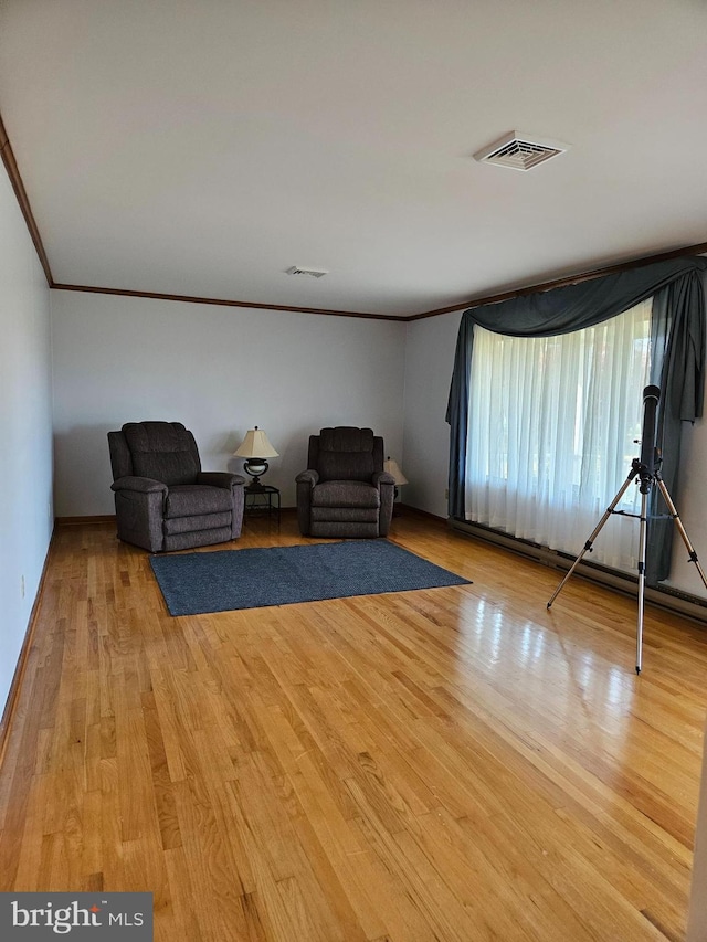 living area featuring light hardwood / wood-style floors and ornamental molding