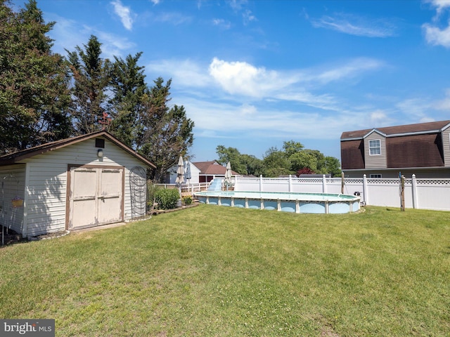 view of yard featuring a fenced in pool and a shed