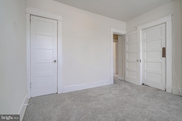 unfurnished bedroom featuring light carpet and a closet