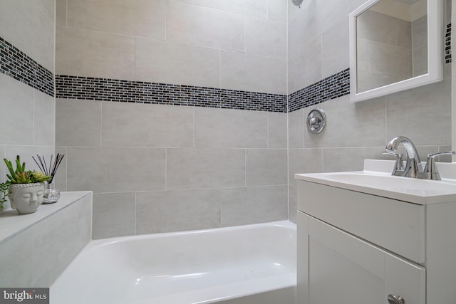 bathroom with vanity, decorative backsplash, tile walls, and tiled shower / bath combo