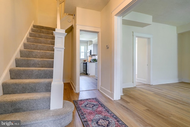 staircase featuring hardwood / wood-style floors and a textured ceiling