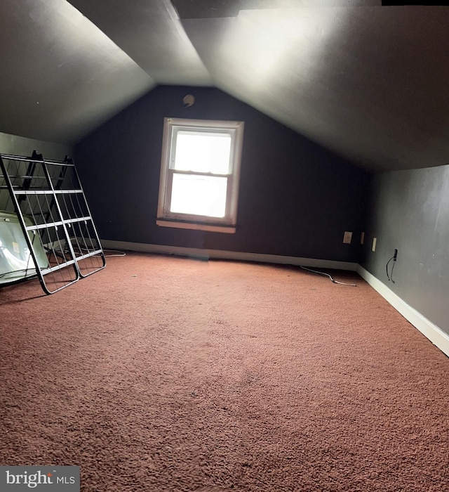 bonus room with vaulted ceiling and carpet