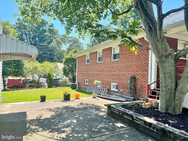 view of side of property with a yard and a patio