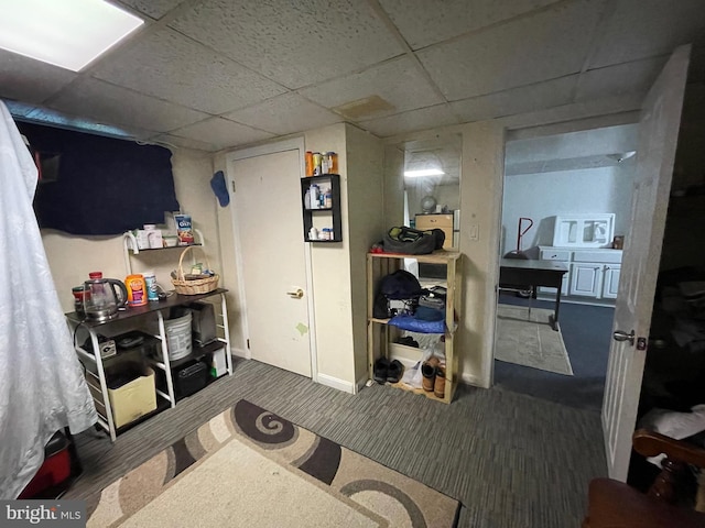 interior space featuring a paneled ceiling and dark carpet