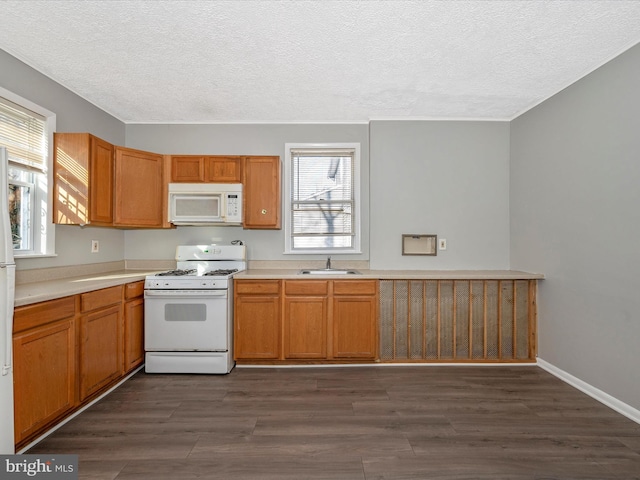 kitchen with a textured ceiling, white appliances, and dark hardwood / wood-style floors