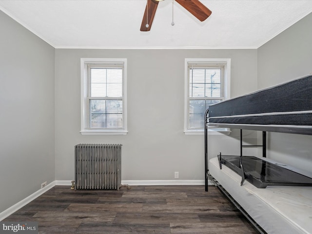 unfurnished bedroom featuring radiator heating unit, dark hardwood / wood-style flooring, and crown molding