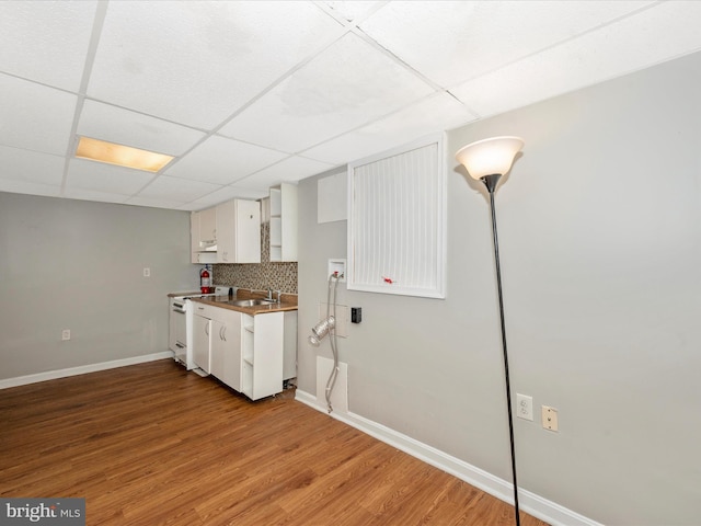 kitchen with white cabinetry, tasteful backsplash, white range oven, light hardwood / wood-style floors, and a paneled ceiling