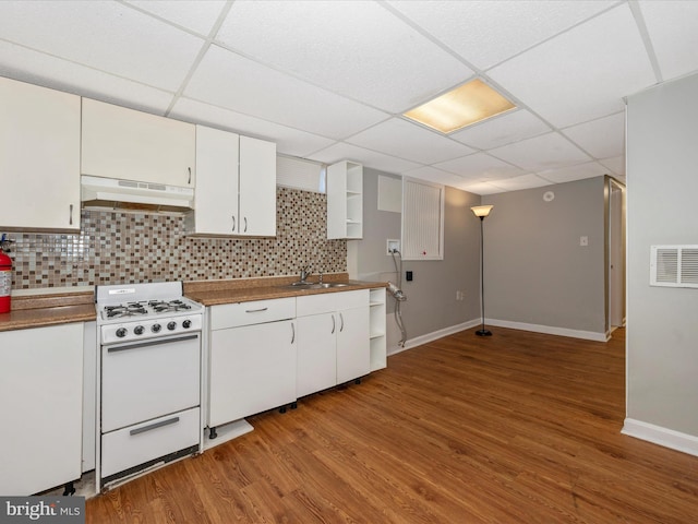 kitchen featuring tasteful backsplash, premium range hood, a drop ceiling, white range, and white cabinetry