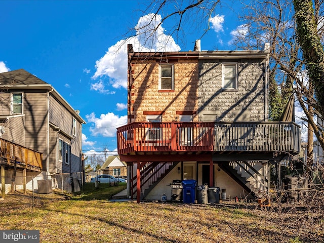 rear view of property featuring a wooden deck, a yard, and central AC unit