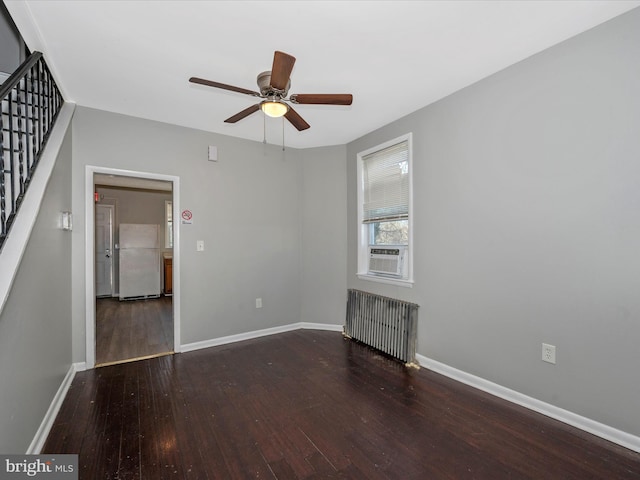 unfurnished living room featuring ceiling fan, cooling unit, dark wood-type flooring, and radiator