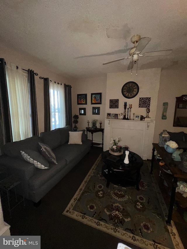 living room with ceiling fan and a textured ceiling