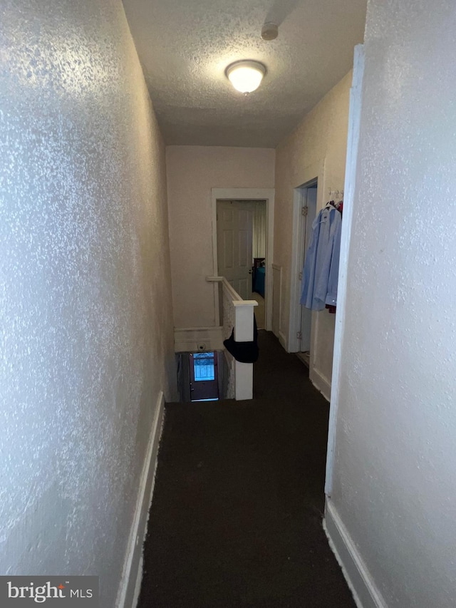 hallway with a textured ceiling