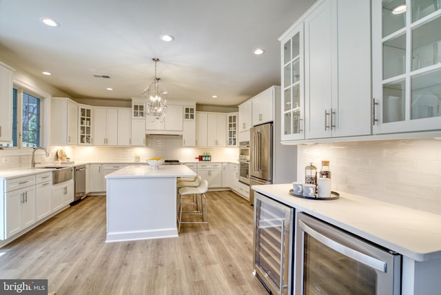 kitchen with white cabinets, a kitchen island, and wine cooler