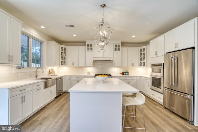 kitchen featuring white cabinetry, sink, a kitchen island, and appliances with stainless steel finishes