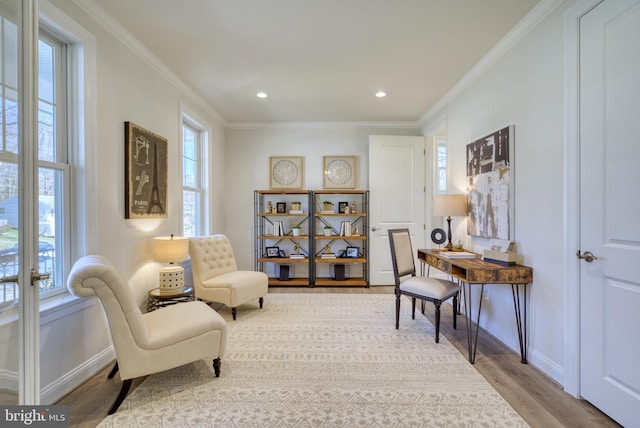 living area featuring light hardwood / wood-style floors and crown molding