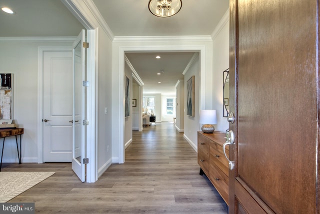 corridor with crown molding and light hardwood / wood-style flooring